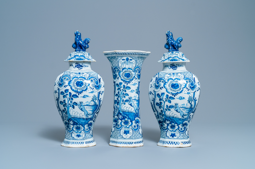 A Dutch Delft blue and white three-piece vase garniture with a dog, 18th C.