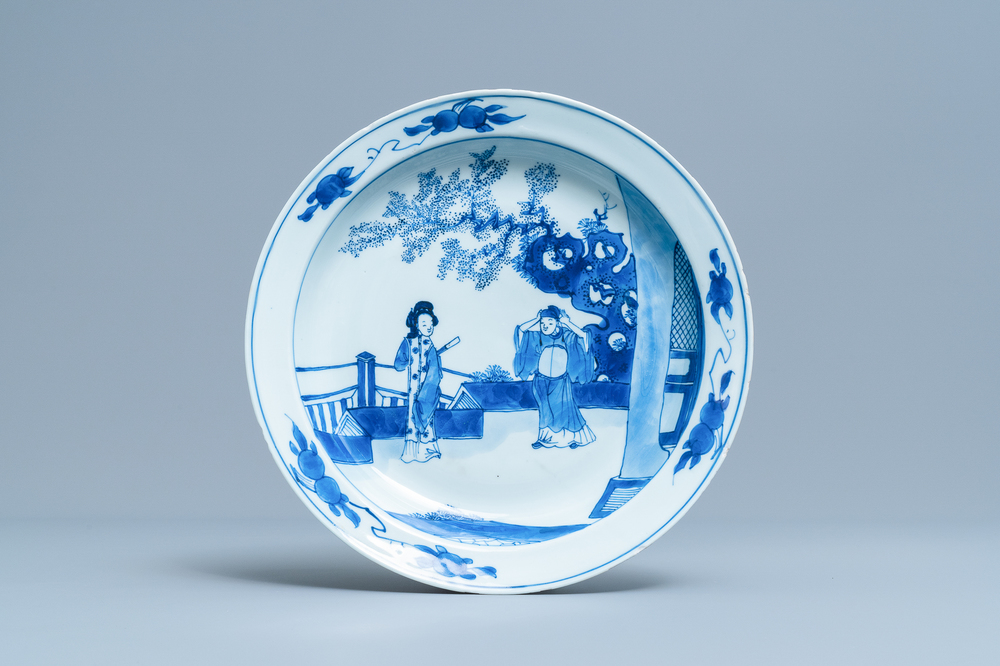 A Chinese blue and white dish with two figures in a garden, Transitional period