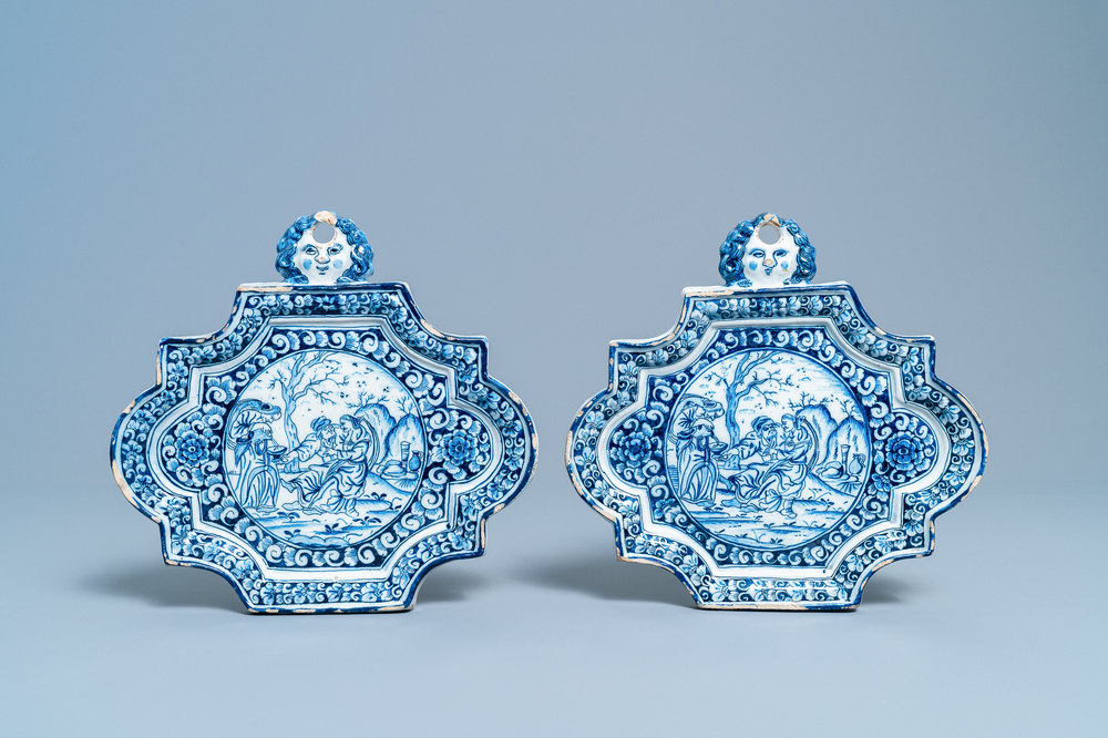 A pair of Dutch Delft blue and white plaques with mascaron suspensions, 18th C.