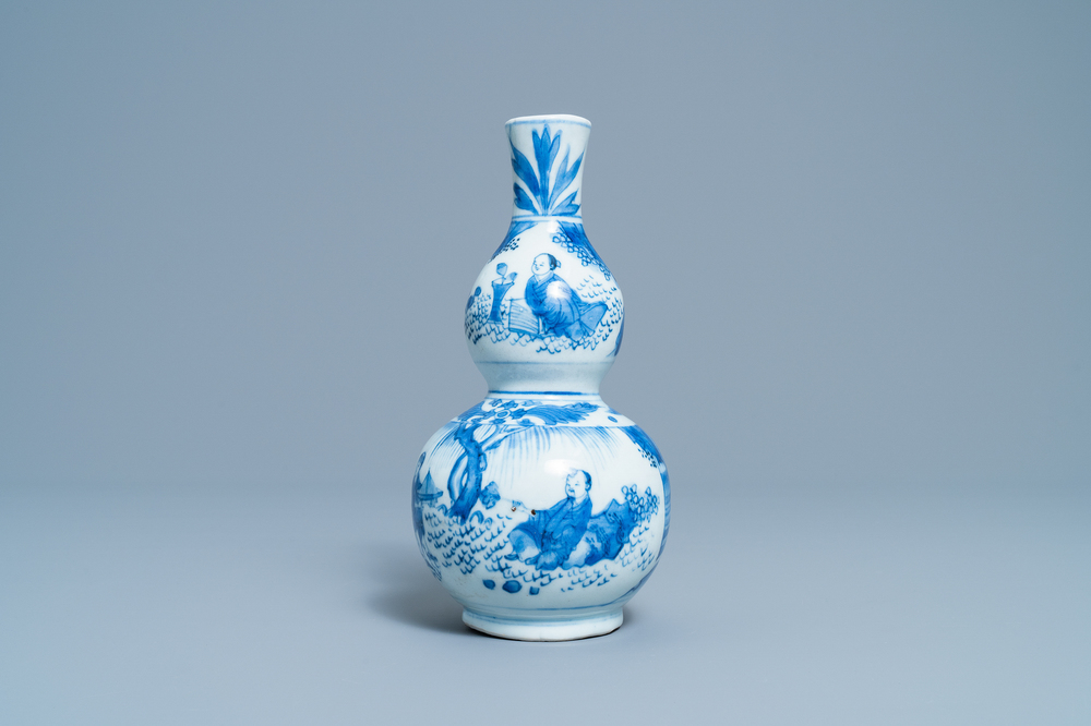 A Chinese blue and white double gourd vase with figures in a landscape, Transitional period