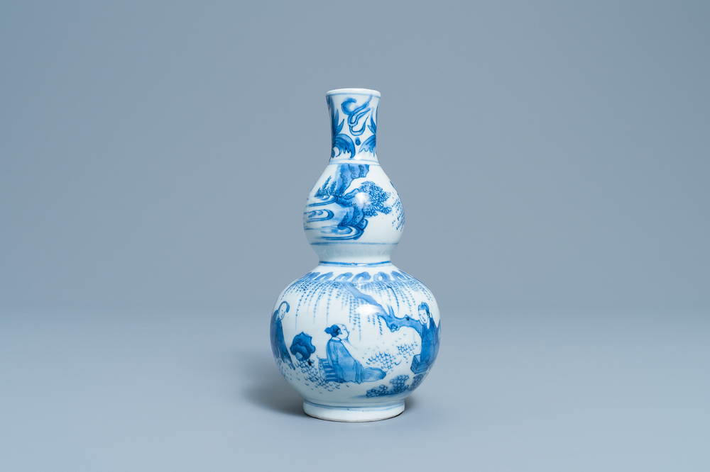 A Chinese blue and white double gourd vase with figures in a landscape, Transitional period