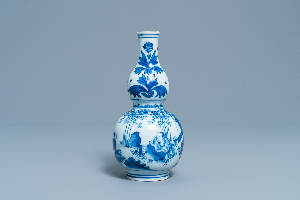 A Chinese blue and white double gourd vase with figures in a landscape, Transitional period