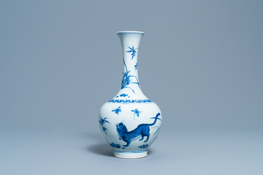 Un vase de forme bouteille en porcelaine de Chine en bleu et blanc &agrave; d&eacute;cor d'un tigre et deux papillons, &eacute;poque Transition