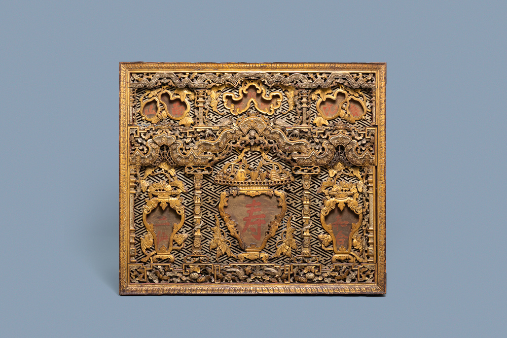 A Chinese carved and gilt wooden panel with red painted characters, 18/19th C.