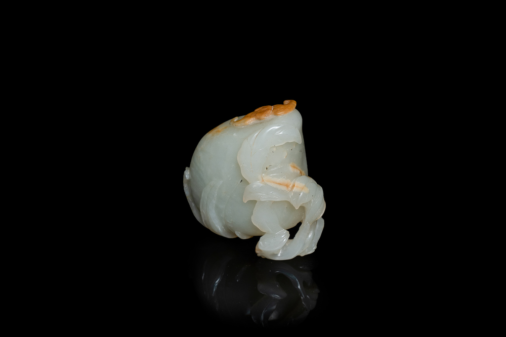 A Chinese pale celadon and russet jade model of a peach, Ming