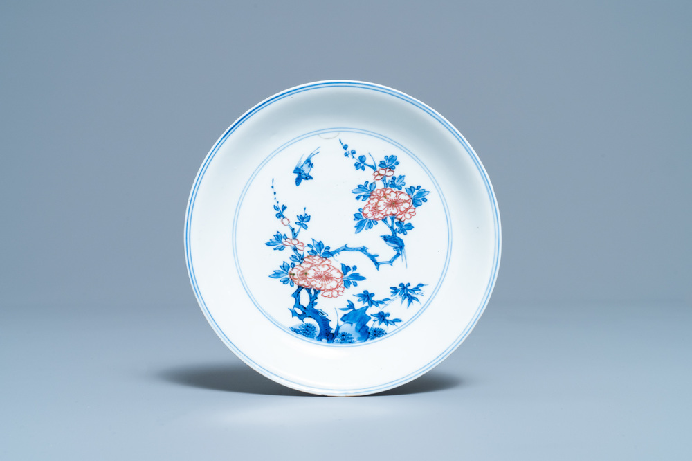 Een Chinees blauw-wit en koperrood bord met floraal decor, Kangxi