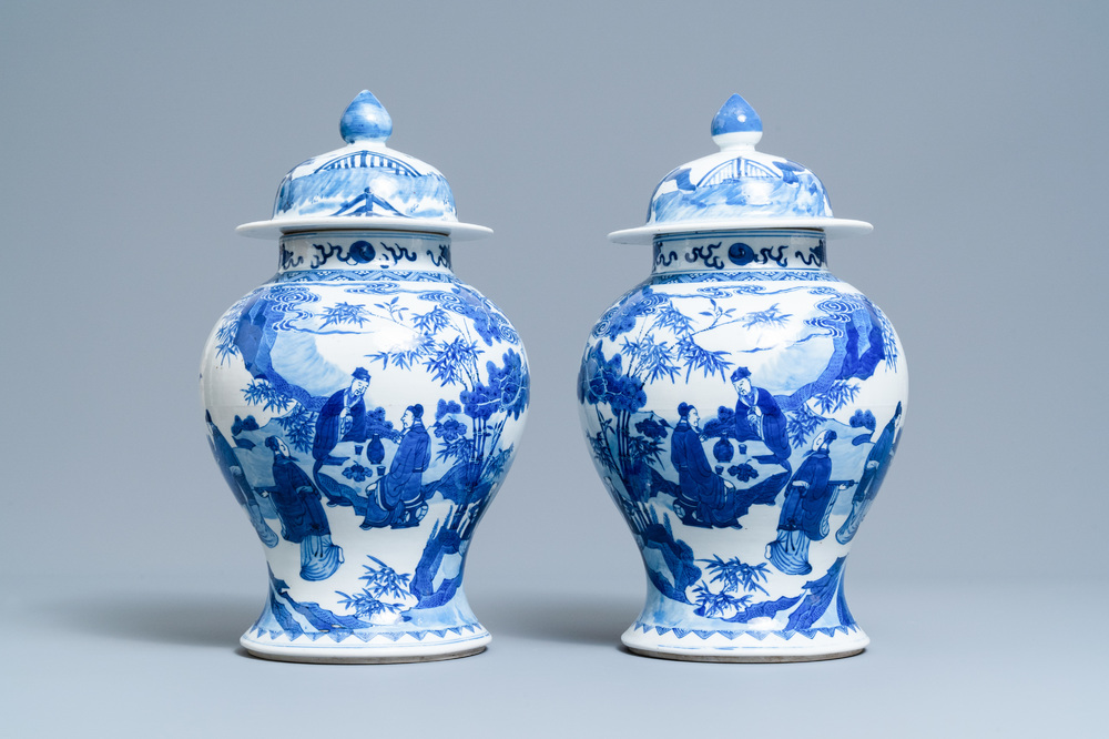 A pair of Chinese blue and white vases and covers with figures in a landscape, 19th C.