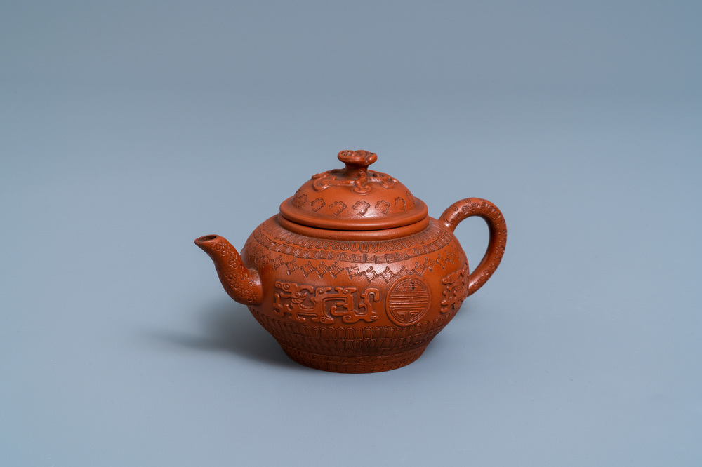 A Chinese Yixing stoneware teapot and cover with applied and impressed design, Kangxi