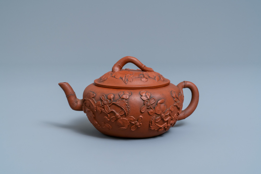 Een Chinese Yixing steengoed theepot met opgelegd floraal decor, Kangxi