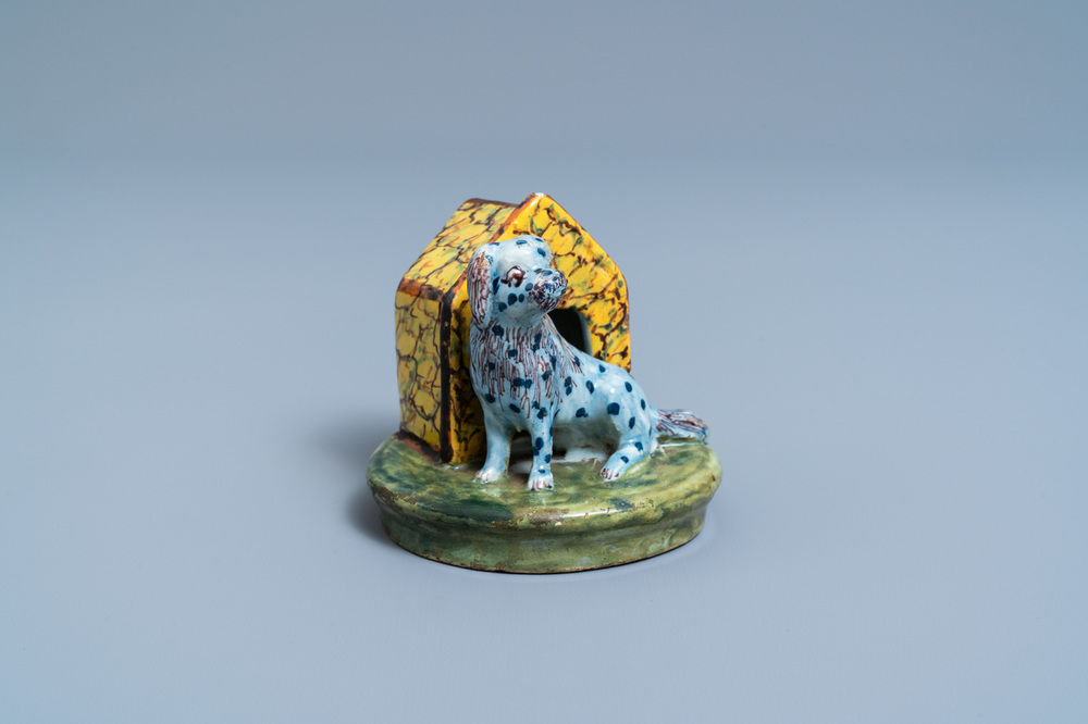 A polychrome Dutch Delft model of a dog by its doghouse, 18th C.