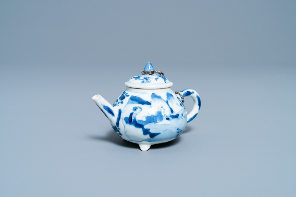 Een Chinese blauw-witte driepotige theepot met figuren in een landschap, Kangxi