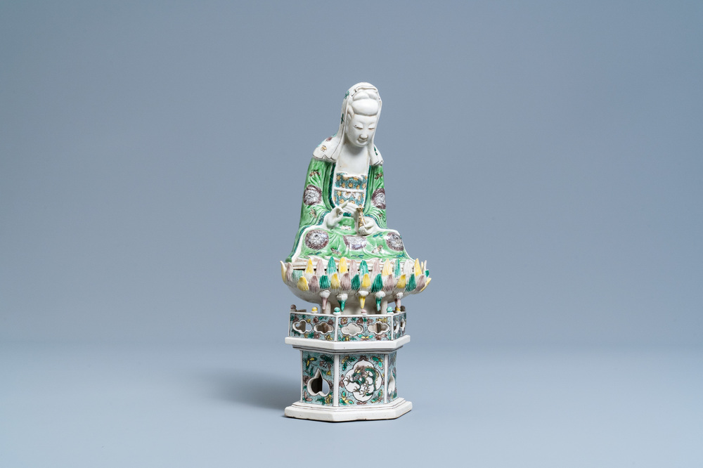 A Chinese verte biscuit group of Guanyin on a lotus throne, Kangxi