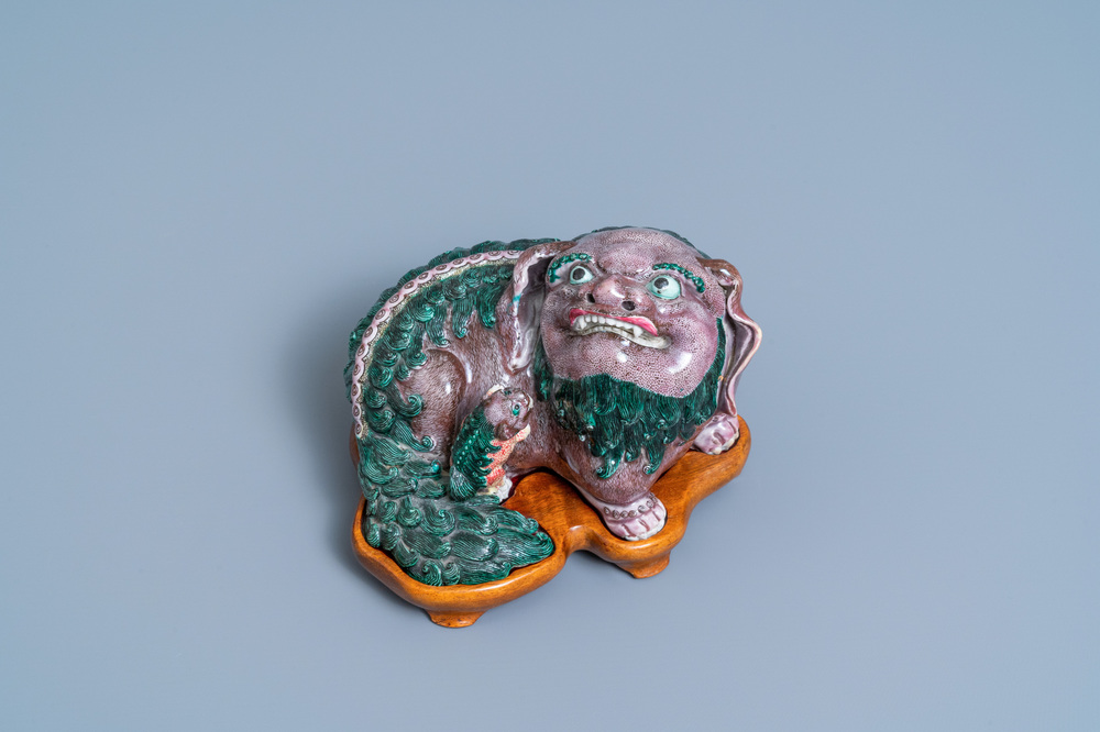 Un groupe en porcelaine de Chine figurant un lion bouddhiste et son lionceau sur socle en bois, 19&egrave;me