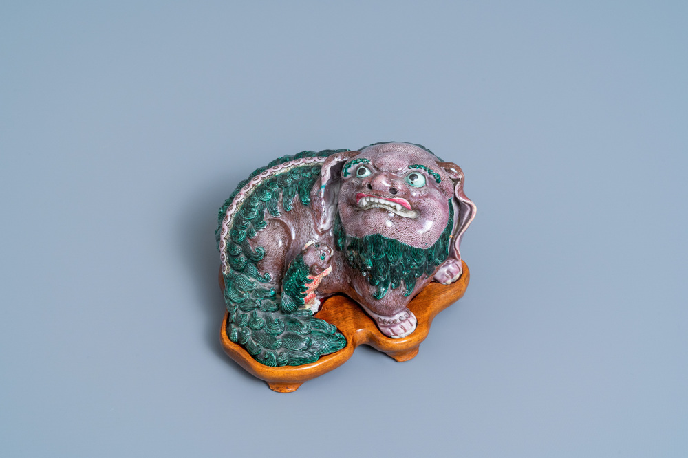 A Chinese porcelain 'Buddhist lion and cub' group on carved wooden stand, 19th C.