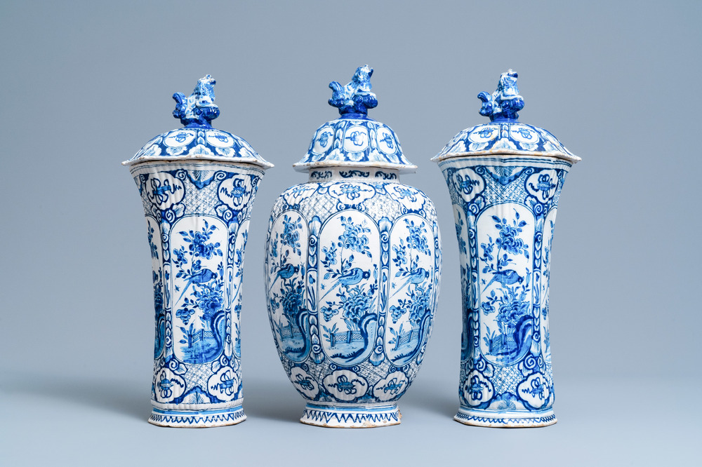 A Dutch Delft blue and white garniture of three vases and covers, 18th C.