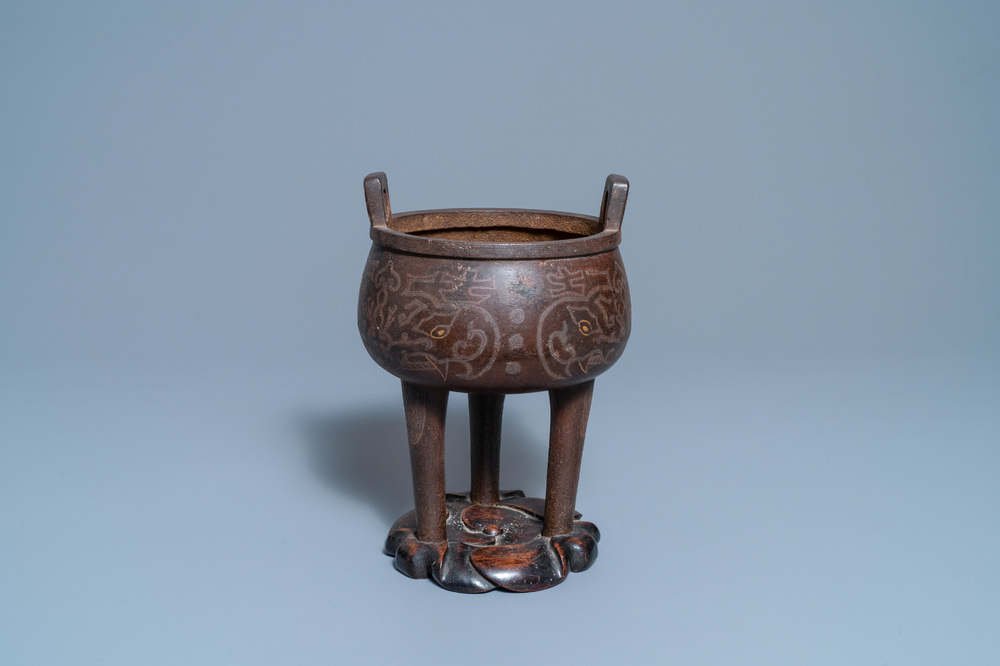 Un br&ucirc;le-parfum en bronze incrust&eacute; sur socle en bois, Chine, Ming