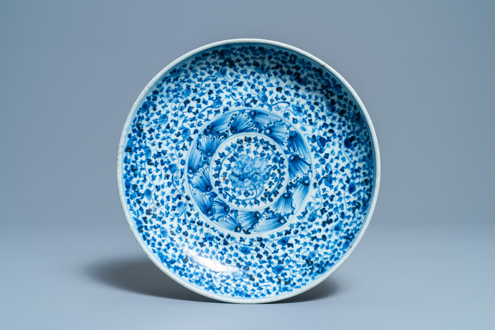 Un plat en porcelaine de Chine en bleu et blanc &agrave; d&eacute;cor floral, Ming