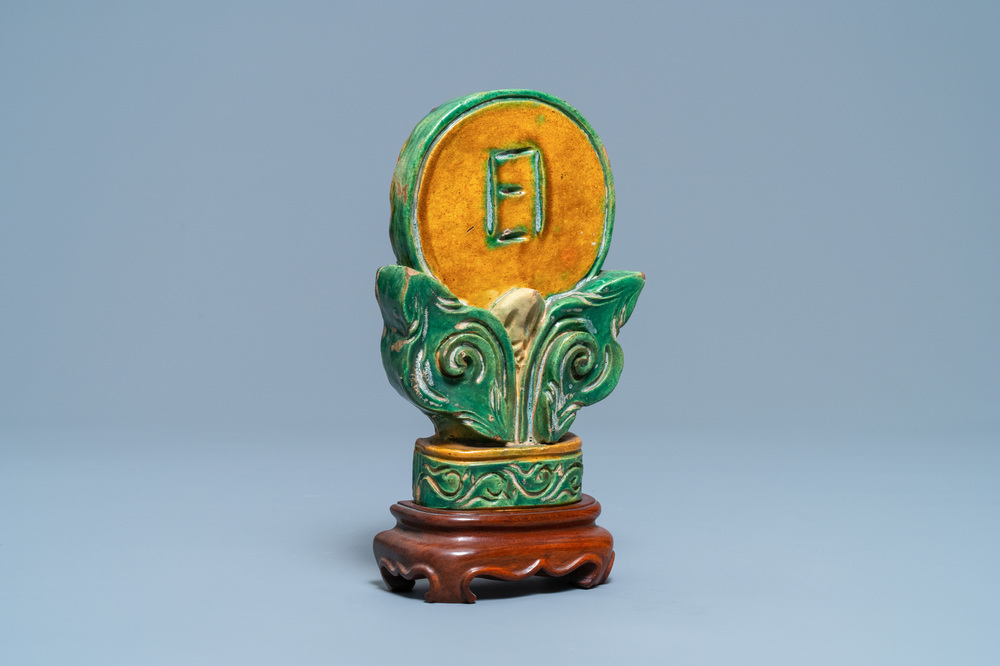 A Chinese sancai-glazed Buddhist emblem on wooden stand, Ming