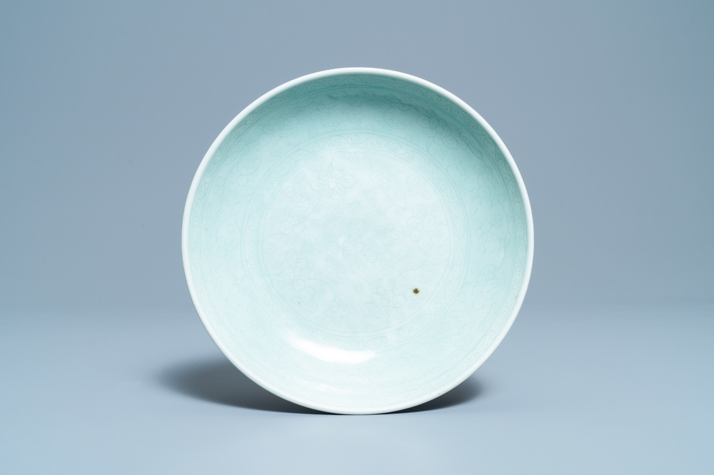 Een Chinese monochrome celadon schotel met onderglazuur decor, Qianlong