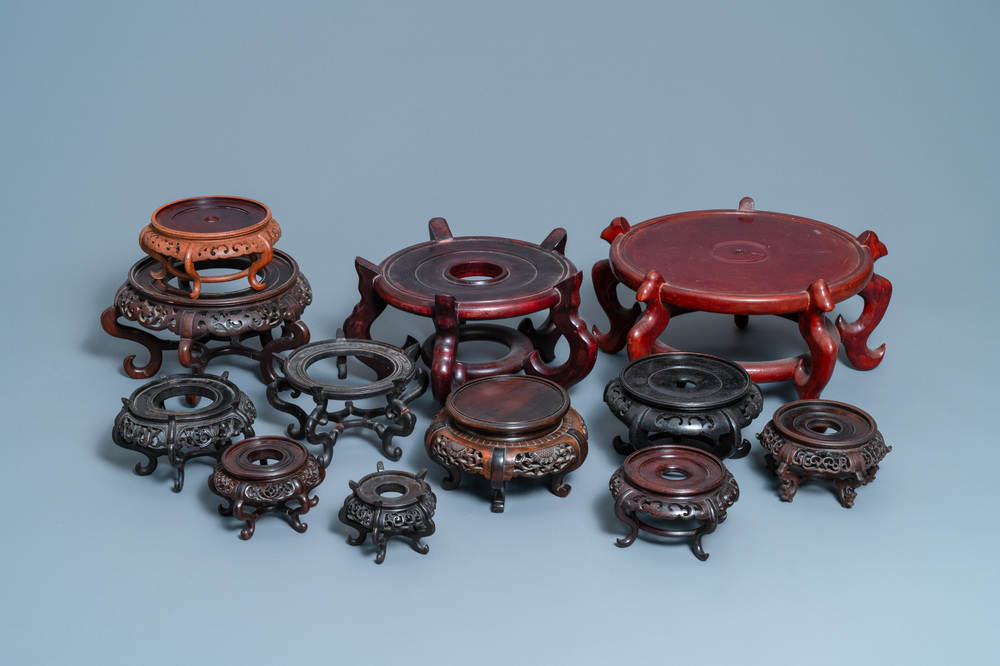 Twelve large round Chinese carved wooden stands, 19/20th C.