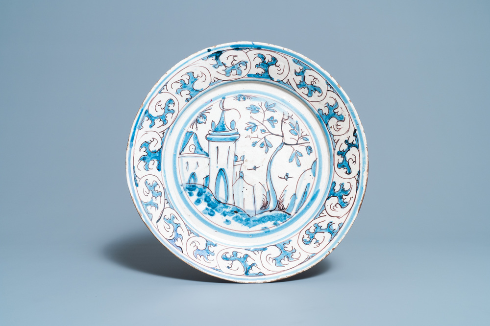 A blue, white and manganese Portuguese faience charger with a castle, 17th C.
