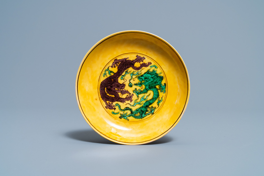 Une coupe en porcelaine de Chine &agrave; d&eacute;cor de dragons en vert et aubergine sur fond jaune, marque et &eacute;poque de Kangxi