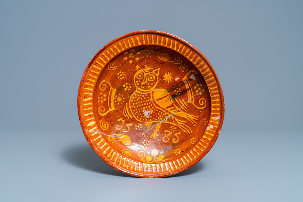 A Dutch slip-decorated pottery dish with an owl, dated 1585