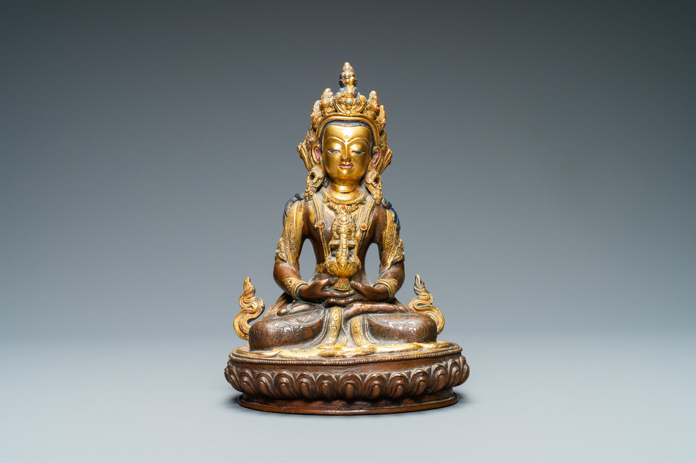 A Nepalese coral- and turquoise-inlaid partly gilded copper alloy figure of Buddha, 19/20th C.
