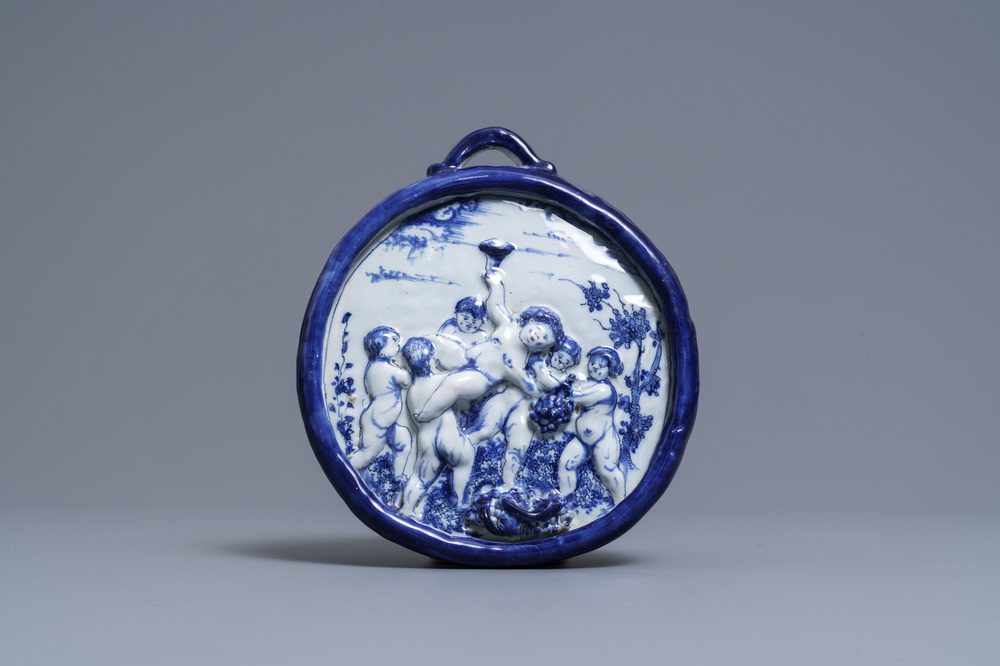 A Dutch Delft blue and white relief-moulded plaque with putti holding grapes, 18th C.