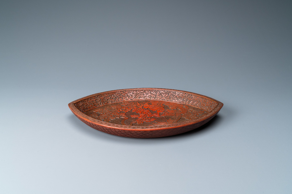 Een Chinese puntige ovale lakwerk schotel met een pauw op een rots, drie-karakter merk, Qianlong