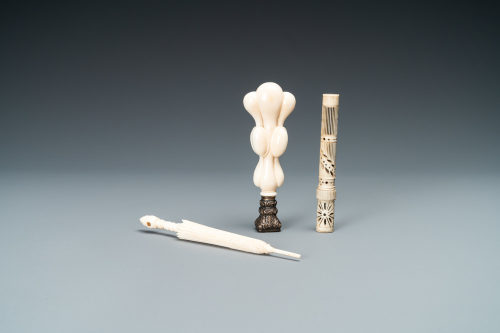 An ivory 'Stanhope' miniature umbrella with microscopical views on Paris, a seal stamp and a bone needle case, 19th C.