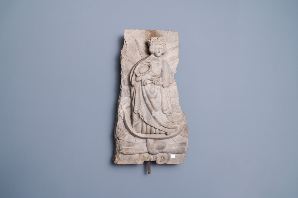 Un relief en gr&egrave;s gris sculpt&eacute; figurant une Vierge &agrave; l'enfant, dat&eacute; 1489