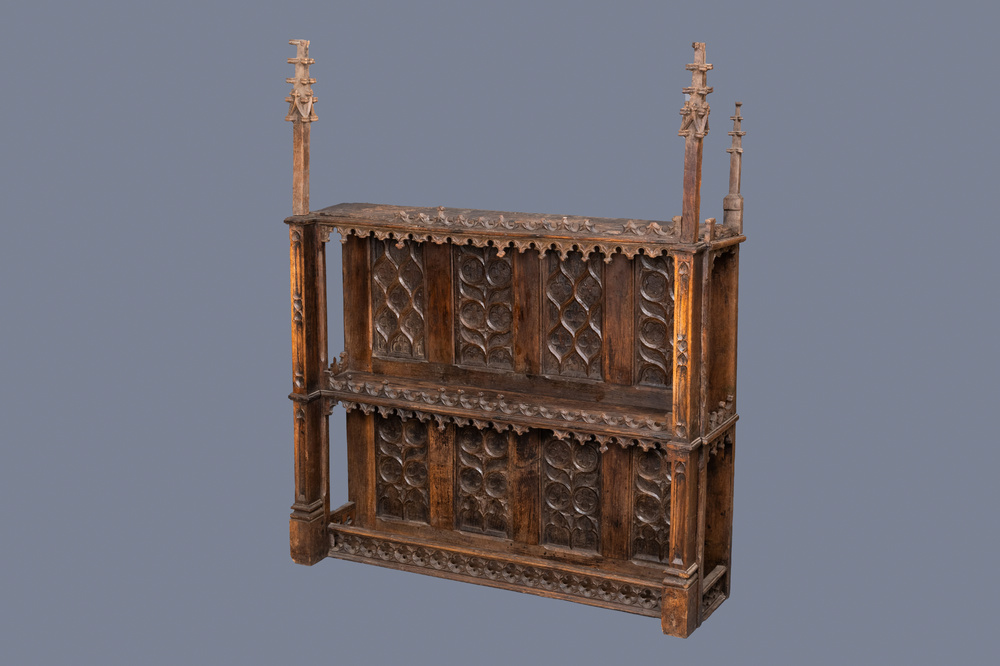 A carved oak shelf with pinnacles and stylised flowers and carved panels, 15th C. and later