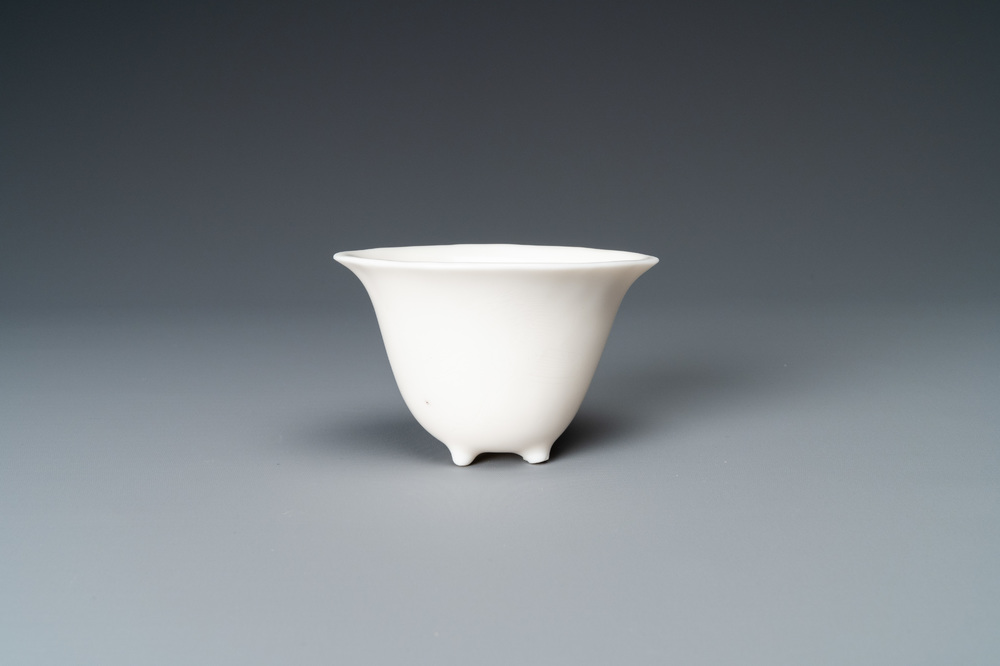 A Chinese Dehua blanc de Chine tripod wine cup with inscription, Kangxi