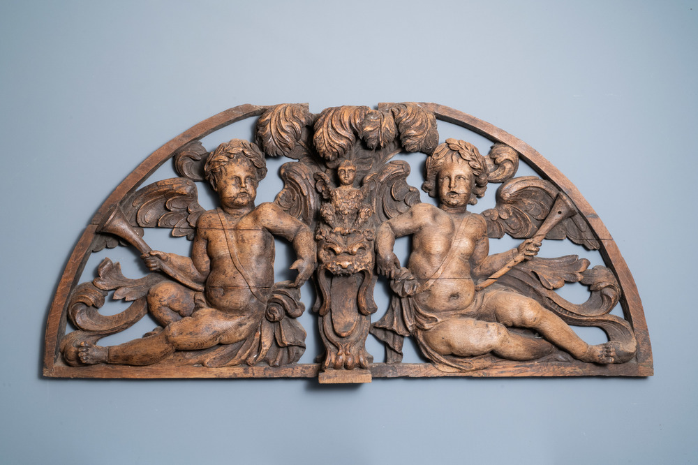 A reticulated carved oak fronton with two winged cherubs holding a horn, France, 17th C.