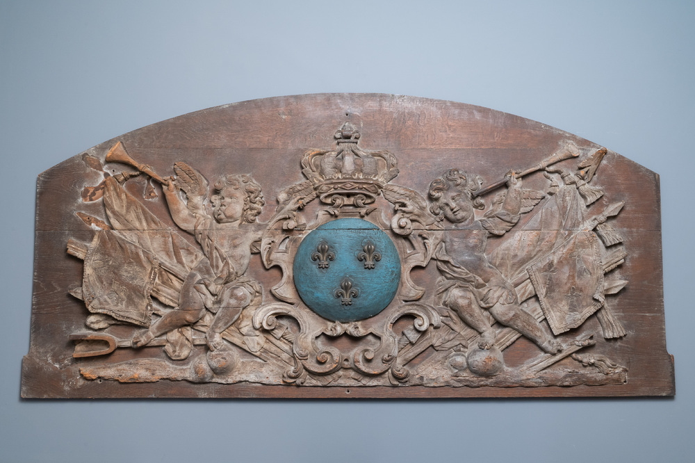 A large polychromed carved oak panel with putti and trophies flanking the royal coat of arms of France, 18th C.
