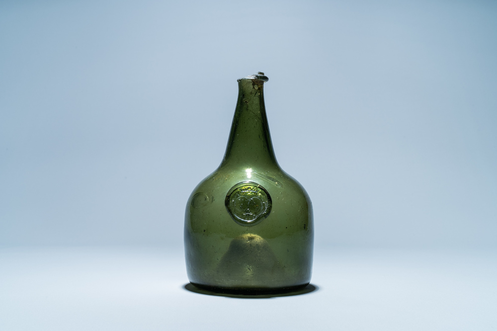 A green glass wine bottle with a crowned alliance seal, 17th C.