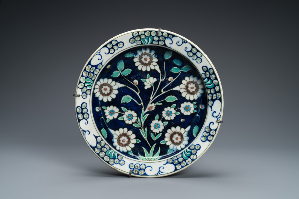 Un plat en c&eacute;ramique de style Iznik &agrave; fond bleu, Kutahya, Turquie, 19&egrave;me