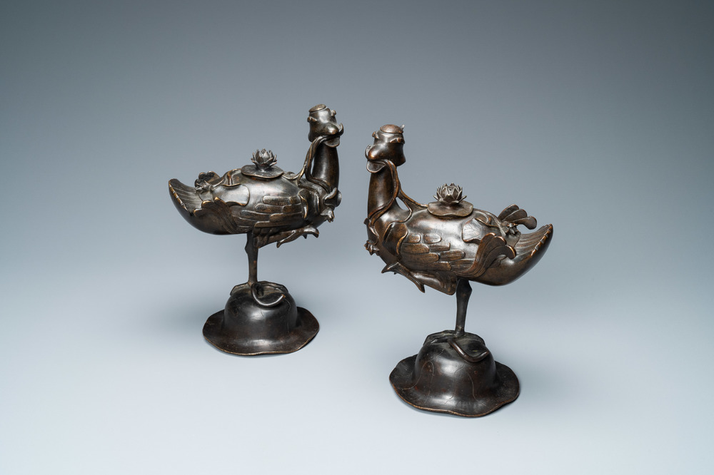 Een paar Chinese bronzen wierookbranders in de vorm van eenden op een lotus, late Ming/vroege Qing