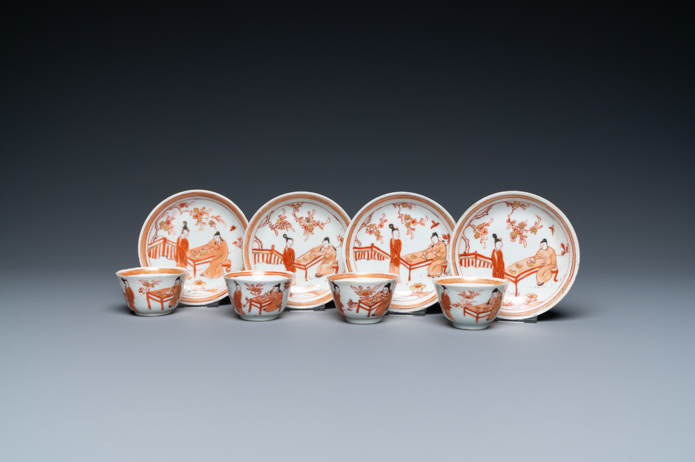 Four Chinese iron-red and gilt cups and saucers with figures near a table, Kangxi