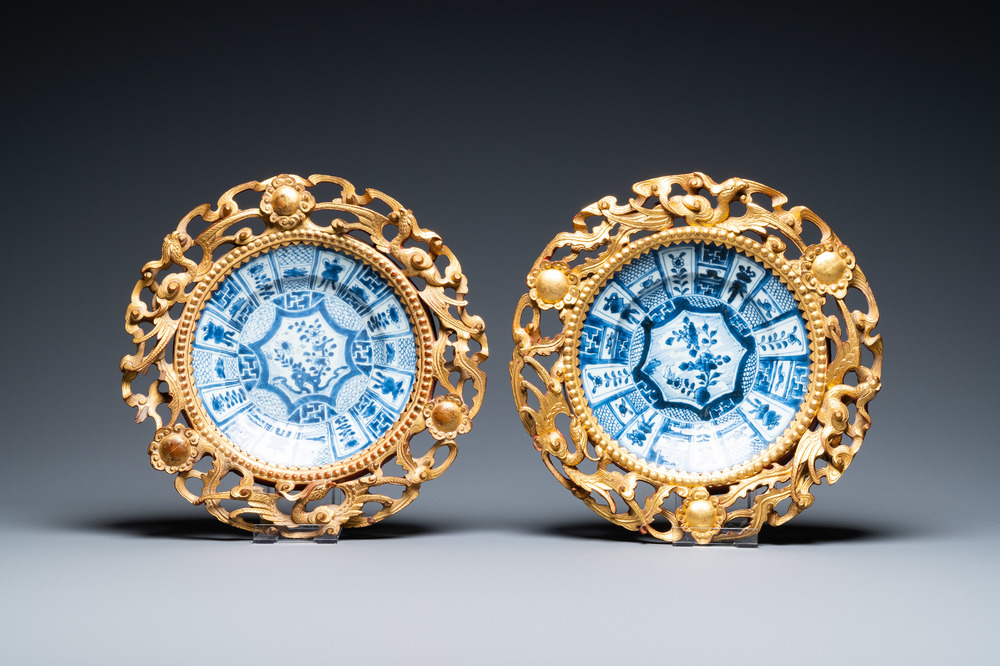 Une paire d'assiettes en porcelaine de Chine en bleu et blanc dans leurs cadres en bois dor&eacute;, Kangxi et 19&egrave;me