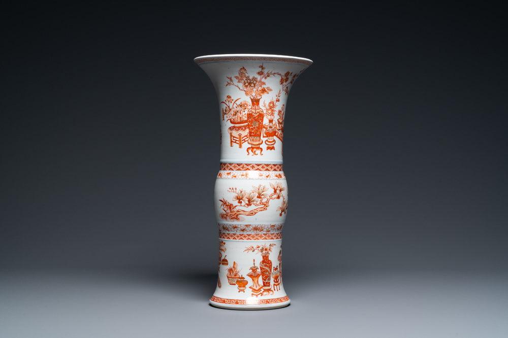 A Chinese iron-red and gilt 'gu' vase with antiquities, Kangxi