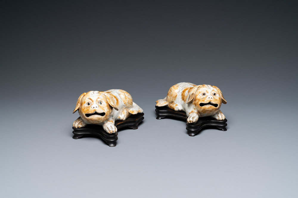 A pair of Chinese porcelain models of reclining dogs, Qianlong/Jiaqing