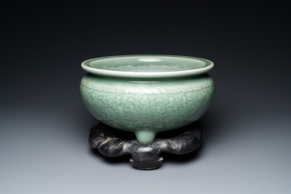 Een Chinese driepotige monochrome celadon wierookbrander met pioenslingers, 18/19e eeuw