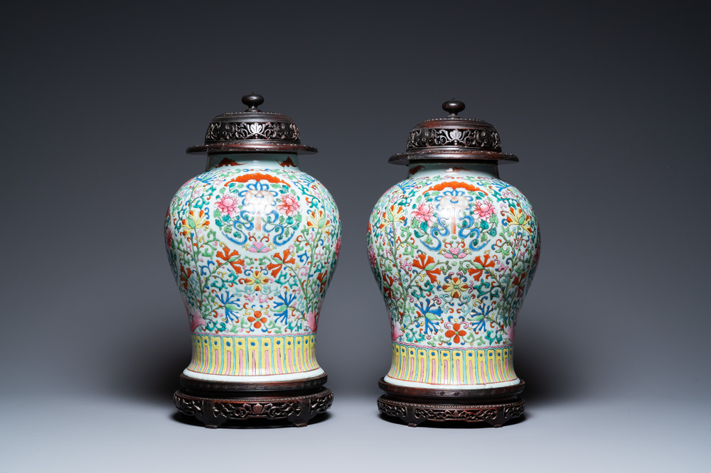 A pair of Chinese famille rose vases with wooden covers and stands, 19th C.