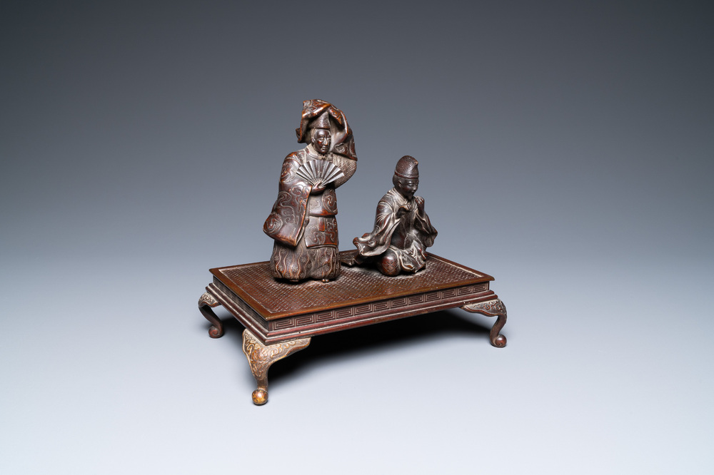 A Japanese bronze okimono depicting two figures on a base, Meiji, 19th C.