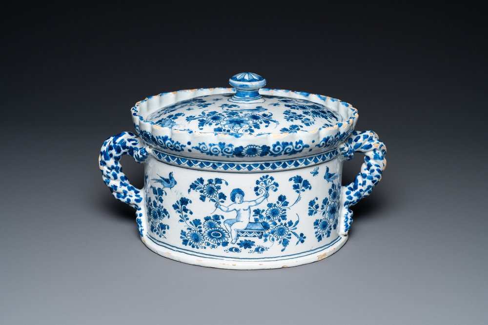 A Dutch Delft blue and white tureen and cover with putti, 17/18th C.