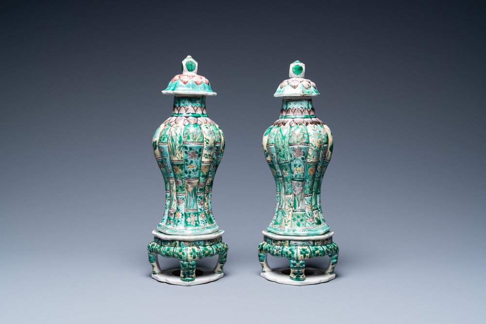 A pair of Chinese verte biscuit vases and covers on stands, Kangxi