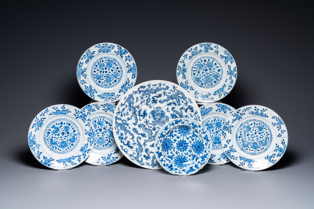 Un plat aux dragons et sept assiettes &agrave; d&eacute;cor floral en porcelaine de Chine en bleu et blanc, Kangxi et apr&egrave;s