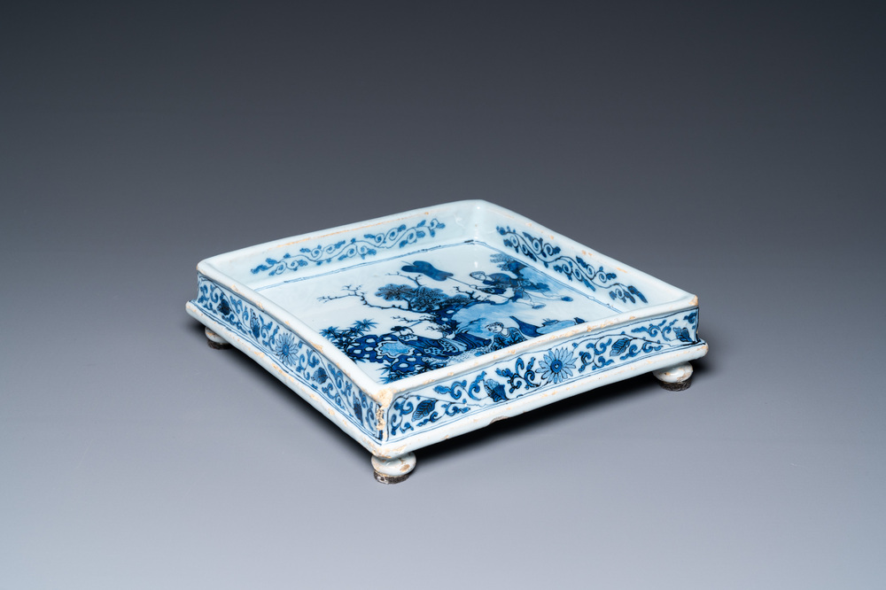 A Dutch Delft blue and white square footed tray on ball feet with chinoiserie design, late 17th C.